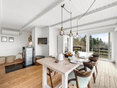 a kitchen and dining room with a wooden table at Holiday Home Heera - 100m to the fjord by Interhome in Lihme