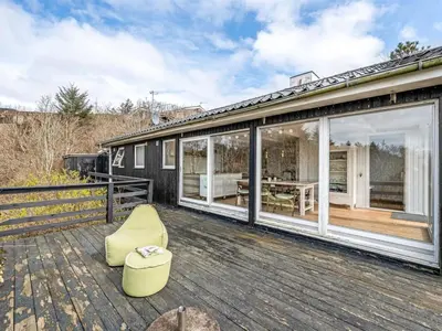 a house with a deck with sliding glass doors at Holiday Home Heera - 100m to the fjord by Interhome in Lihme