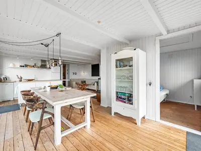 a kitchen and dining room with a white table and chairs at Holiday Home Heera - 100m to the fjord by Interhome in Lihme