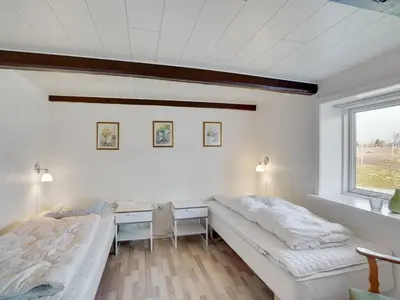a bedroom with two beds and a desk and a window at Holiday Home Kara - 100m to the fjord by Interhome in Fur