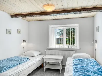 two beds in a room with a window at Holiday Home Kara - 100m to the fjord by Interhome in Fur
