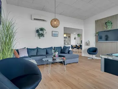 a living room with a blue couch and a table at Holiday Home Eloise - 50m to the fjord by Interhome in Roslev