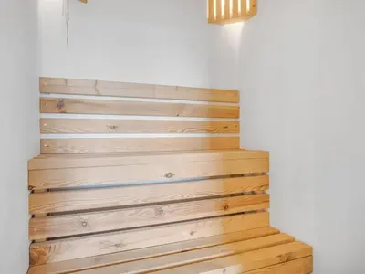 a wooden staircase in a room with a white wall at Holiday Home Eloise - 50m to the fjord by Interhome in Roslev