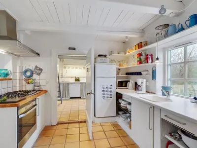 a kitchen with white cabinets and a white refrigerator at Holiday Home Althea - 750m to the fjord by Interhome in Fur