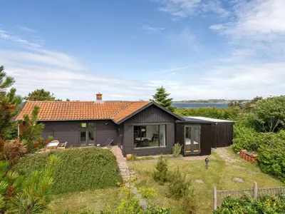 a small black house with a garden in front of it at Holiday Home Lok - 90m to the fjord by Interhome in Roslev