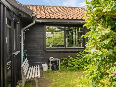 a bench sitting outside of a house with a window at Holiday Home Lok - 90m to the fjord by Interhome in Roslev