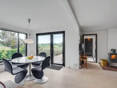a white living room with a table and chairs at Holiday Home Lok - 90m to the fjord by Interhome in Roslev