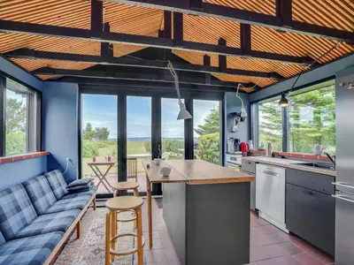 a kitchen with a couch and a table in a room at Holiday Home Lok - 90m to the fjord by Interhome in Roslev