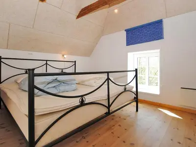 a bedroom with a black bed in a room at Holiday Home Alois - 1km to the fjord by Interhome in Hesselbjerg