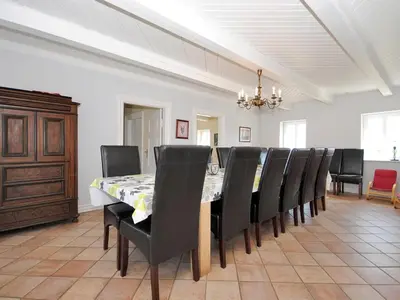 a dining room with a long table and black chairs at Holiday Home Alois - 1km to the fjord by Interhome in Hesselbjerg