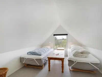 two beds in a white room with a window at Holiday Home Femija - 500m to the fjord by Interhome in Roslev