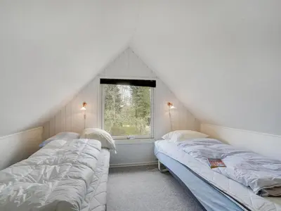 two beds in a room with a window at Holiday Home Femija - 500m to the fjord by Interhome in Roslev