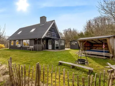 a house with a black roof and a swing at Holiday Home Thyra - 500m to the fjord by Interhome in Fur