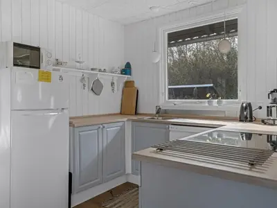 a kitchen with white cabinets and a white refrigerator at Holiday Home Thyra - 500m to the fjord by Interhome in Fur