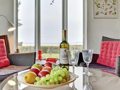 a bottle of wine sitting on a table with a bowl of fruit at Holiday Home Kaleva - 200m to the fjord by Interhome in Fur
