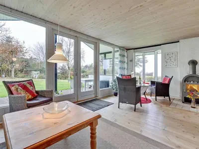 a living room with a table and a fireplace at Holiday Home Kaleva - 200m to the fjord by Interhome in Fur
