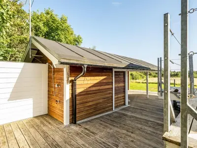 a wooden garage with a roof on a deck at Holiday Home Eljas - 200m to the fjord by Interhome in Fur