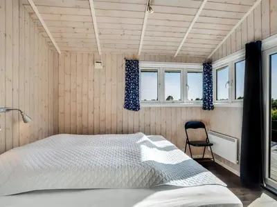 a bedroom with a bed and a chair in it at Holiday Home Eljas - 200m to the fjord by Interhome in Fur