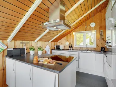 a kitchen with white cabinets and a wooden ceiling at Holiday Home Henrieke - 250m to the fjord by Interhome in Roslev