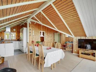 a kitchen and dining room with a table and chairs at Holiday Home Henrieke - 250m to the fjord by Interhome in Roslev