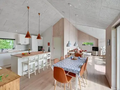 a kitchen and dining room with a table and chairs at Holiday Home Regni - 300m to the fjord by Interhome in Nykøbing Mors