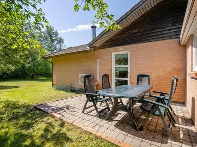 a patio with a table and chairs in front of a house at Holiday Home Tille - 700m to the fjord by Interhome in Roslev