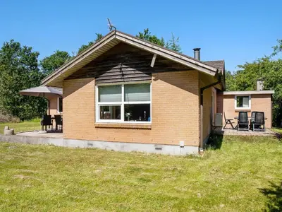 a small house with a large window in a yard at Holiday Home Tille - 700m to the fjord by Interhome in Roslev