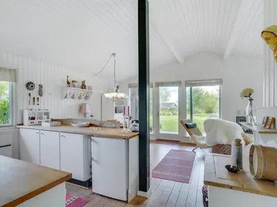 a kitchen with white cabinets and a table at Holiday Home Suoma - 400m to the fjord by Interhome in Roslev