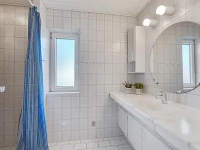 a white bathroom with a sink and a mirror at Holiday Home Auguste - 1-5km to the fjord by Interhome in Fur