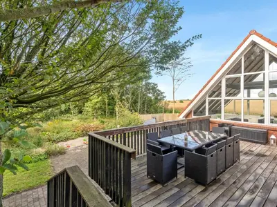 a wooden deck with a table and chairs on it at Holiday Home Auguste - 1-5km to the fjord by Interhome in Fur