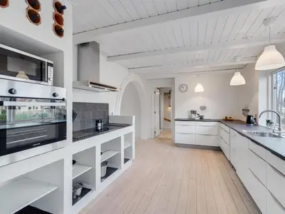 a large white kitchen with white cabinets and appliances at Holiday Home Auguste - 1-5km to the fjord by Interhome in Fur