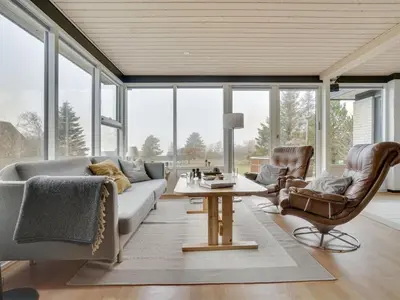 a living room with a couch and chairs and a table at Holiday Home Lefke - 400m to the fjord by Interhome in Roslev