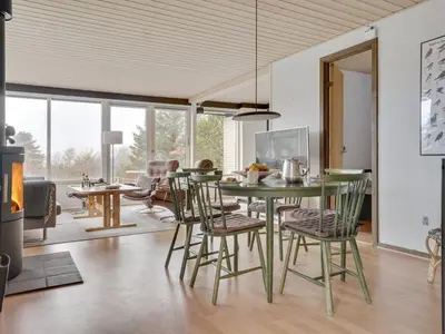a dining room with a green table and chairs at Holiday Home Lefke - 400m to the fjord by Interhome in Roslev