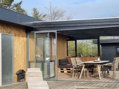 a patio with a table and chairs on a deck at Holiday Home Lefke - 400m to the fjord by Interhome in Roslev