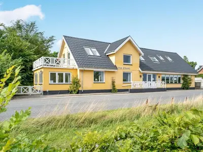 a yellow house on the side of a road at Holiday Home Rina - 30m to the fjord by Interhome in Fur
