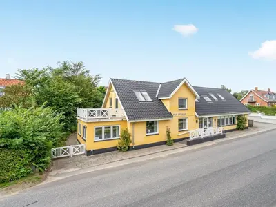 a yellow house with a black roof on a street at Holiday Home Rina - 30m to the fjord by Interhome in Fur