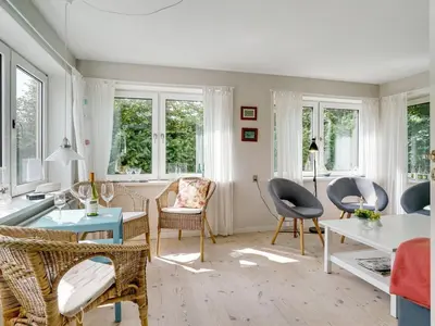 a living room with chairs and a table and windows at Holiday Home Rina - 30m to the fjord by Interhome in Fur