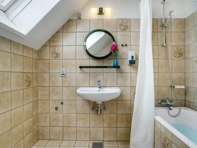 a bathroom with a sink and a tub and a mirror at Holiday Home Rina - 30m to the fjord by Interhome in Fur