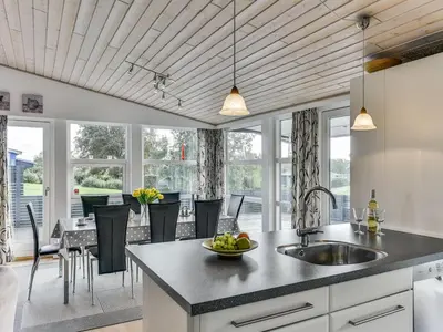 a kitchen with a sink and a table and chairs at Holiday Home Sylvelin - 400m to the fjord by Interhome in Roslev