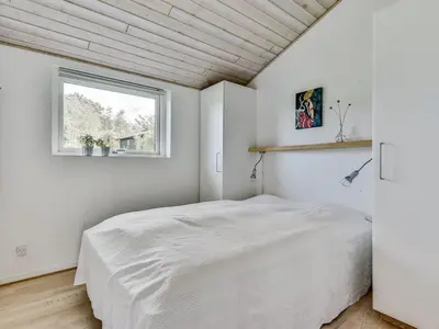 a bedroom with a white bed in a room with a window at Holiday Home Sylvelin - 400m to the fjord by Interhome in Roslev