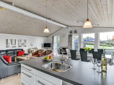 a kitchen with a sink and a living room at Holiday Home Sylvelin - 400m to the fjord by Interhome in Roslev