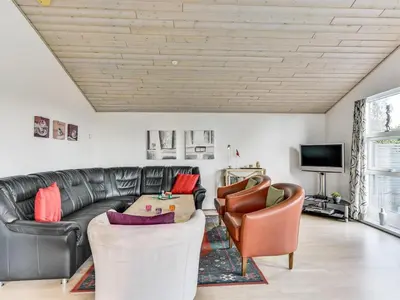 a living room with a leather couch and chairs at Holiday Home Sylvelin - 400m to the fjord by Interhome in Roslev