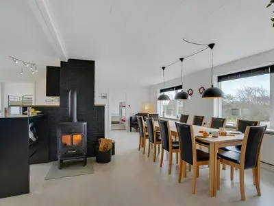 a dining room with a table and chairs and a fireplace at Holiday Home Imilie - 250m to the fjord by Interhome in Redsted