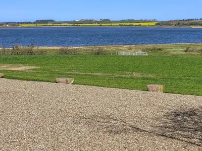 a park with a bench next to a body of water at Holiday Home Imilie - 250m to the fjord by Interhome in Redsted