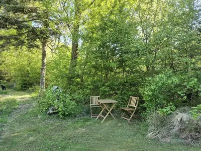 a picnic table and two chairs in the grass at Holiday Home Aswarth - 50m to the fjord by Interhome in Fur
