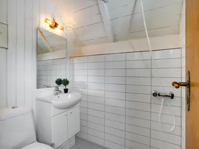 a white bathroom with a toilet and a sink at Holiday Home Aswarth - 50m to the fjord by Interhome in Fur