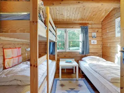 a bedroom with bunk beds in a log cabin at Holiday Home Thrine - 100m to the fjord by Interhome in Fur