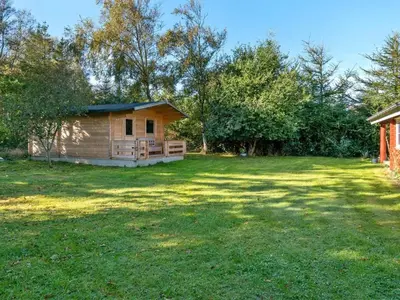 a cabin in the middle of a grassy yard at Holiday Home Thrine - 100m to the fjord by Interhome in Fur