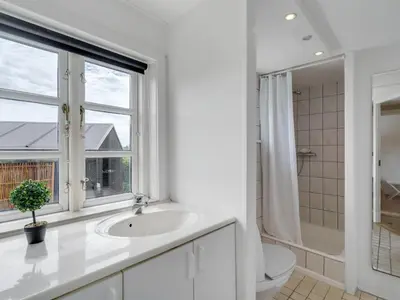 a bathroom with a sink and a toilet and a window at Holiday Home Gren - 90m to the fjord by Interhome in Roslev