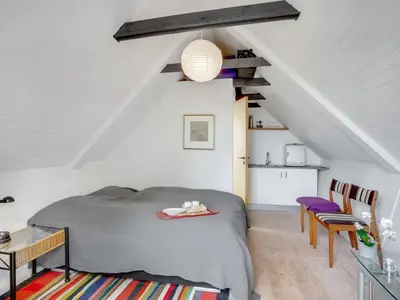 a bedroom with a bed and a table in a attic at Holiday Home Brunhild - 300m to the fjord by Interhome in Fur